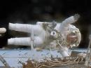 Astronaut Jack Fischer, K2FSH, waves while attached to the Destiny laboratory during a spacewalk to replace a failed data relay box and install a pair of antennas. [NASA photo]